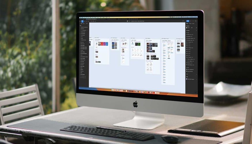 Photo of UX Design deliverables organized on a computer screen sitting on a desktop.