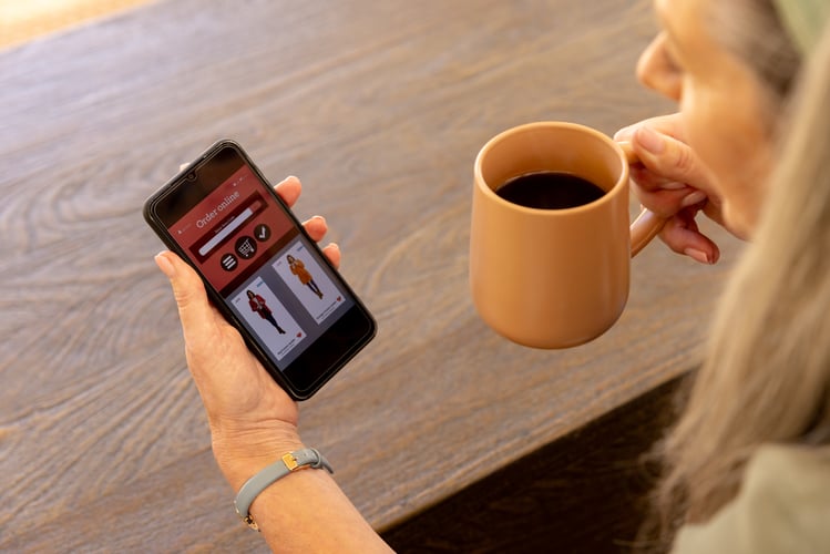 Background image of Browsing online shopping on smartphone, mature woman holding coffee mug at home