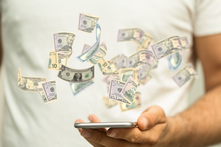 Background image of Male hand holding a smartphone and flying dollar banknotes concept of people make money online