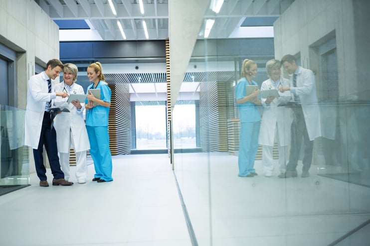 medical-team-discussing-over-digital-tablet-in-cor-2023-11-27-05-14-04-utc