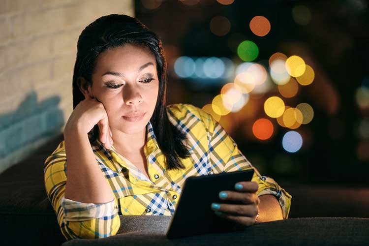 woman-reading-ebook-on-sofa-at-night-2021-08-29-16-24-43-utc