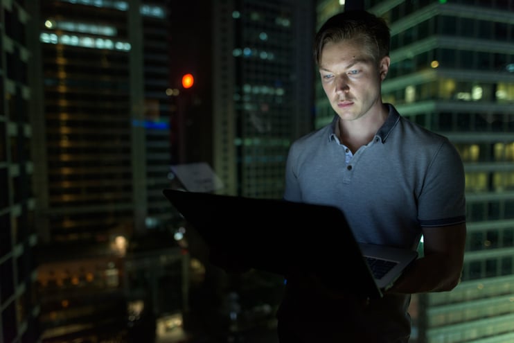 young-handsome-man-using-laptop-against-glass-wind-2023-11-27-04-58-29-utc
