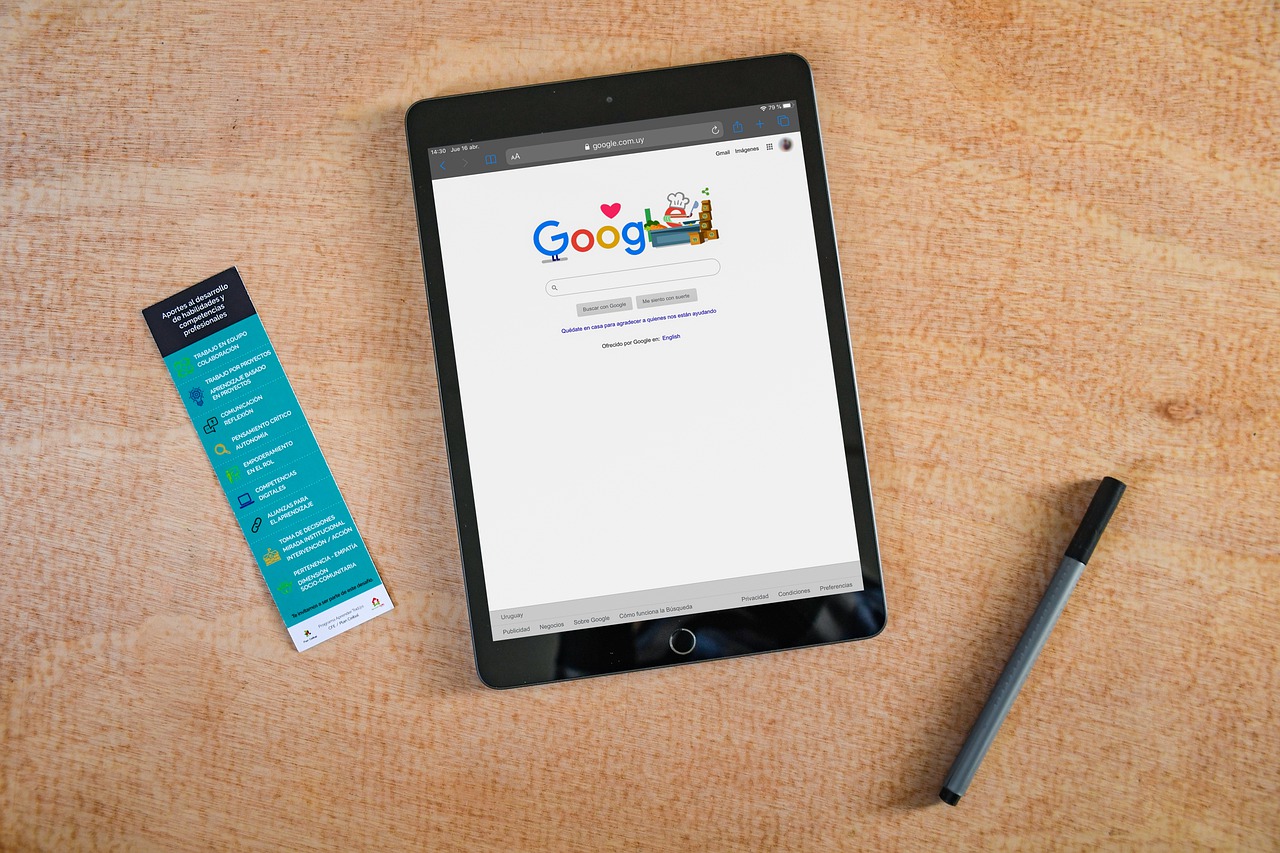A tablet using Google is displayed with a pen beside it.